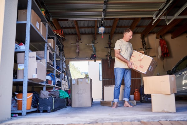 clearing-out-some-things-shot-man-carrying-box-garage